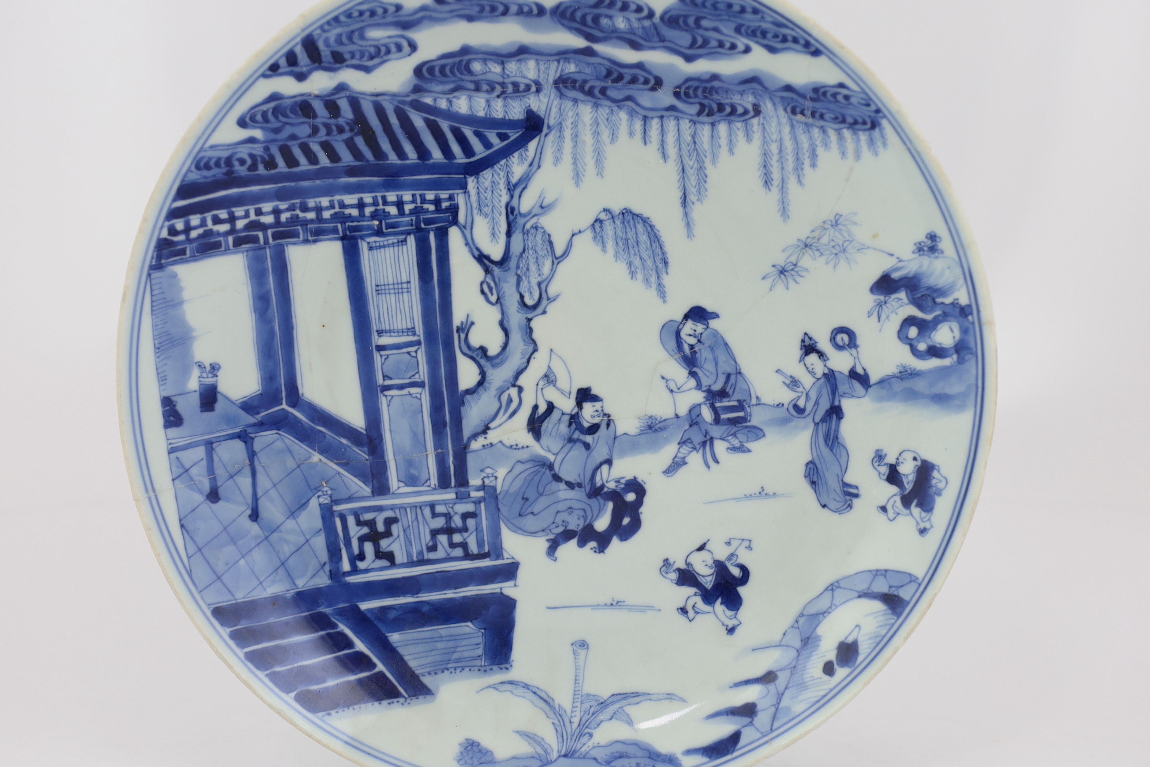 A Chinese blue and white dish, Kangxi period, broken and messily reglued